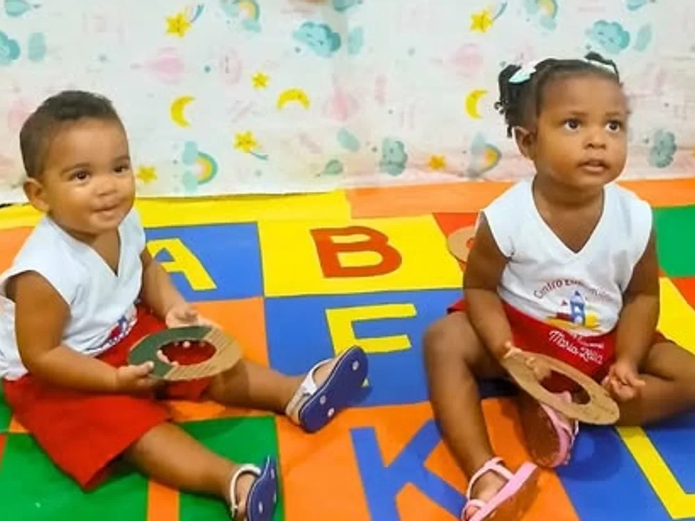 Os pequenos brincando no tapete do alfabeto
