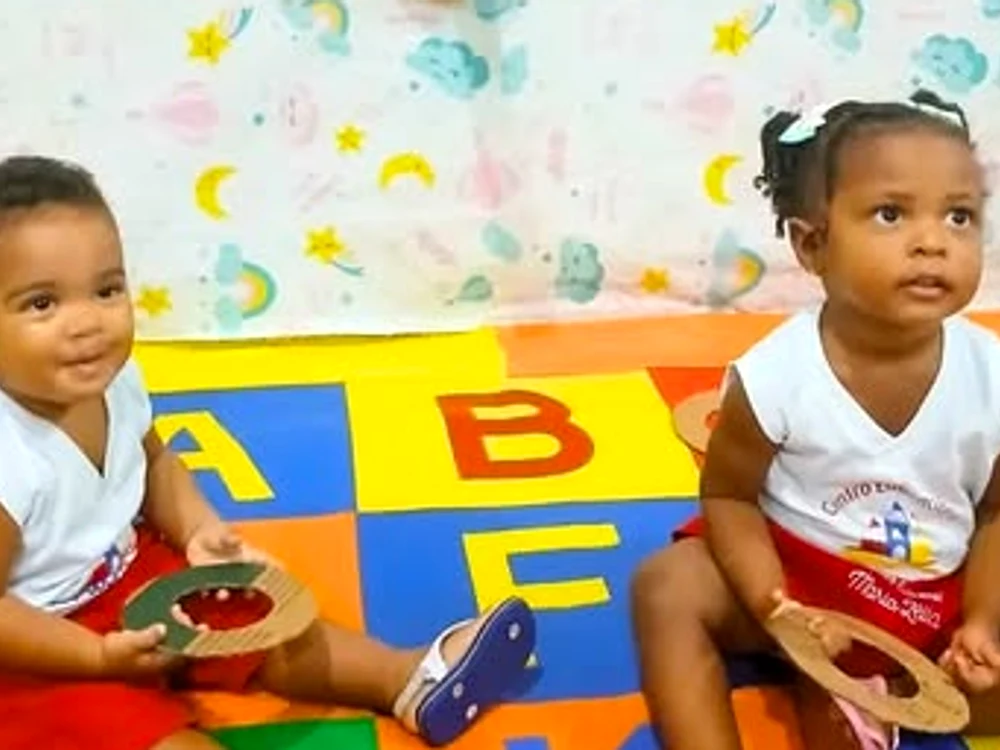 Os pequenos brincando no tapete do alfabeto